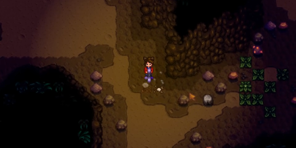 Player exploring a lower floor of the Mines in Stardew Valley surrounded by rocks and ore nodes while progressing toward Floor 100.
