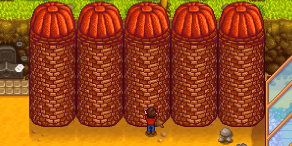Multiple silos built on a Stardew Valley farm for storing hay after cutting grass, preparing livestock for Fall and Winter.